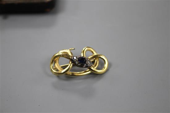 A late Victorian yellow and white metal, sapphire and diamond set scrolling serpent brooch, 32mm, gross 4.5 grams.
